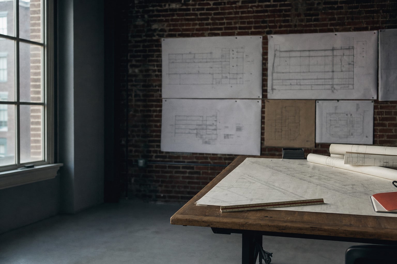 A project team meets around a table covered with drawings
